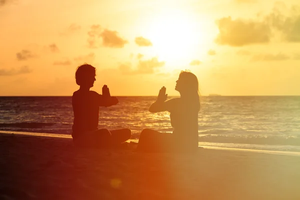 日没でヨガをやっているカップルのシルエット — ストック写真