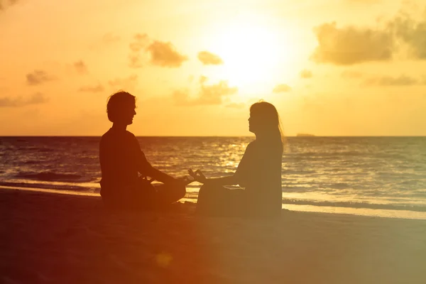 Silueta de pareja haciendo yoga al atardecer — Foto de Stock