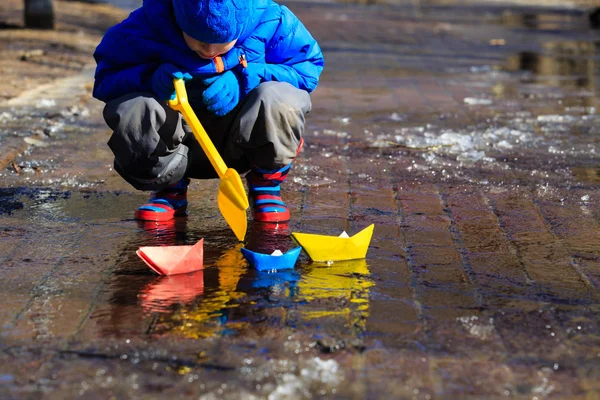 Niño jugando con barcos de papel en primavera — Foto de Stock