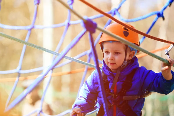 Mały chłopiec wspinaczki w parku przygody z urządzenia bezpieczeństwa — Zdjęcie stockowe