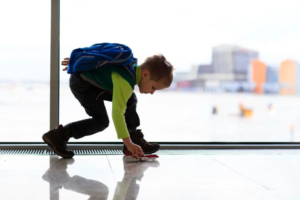 Liten pojke leker med leksak plan på flygplatsen — Stockfoto