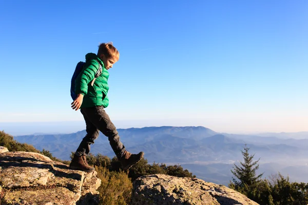 Liten pojke med ryggsäck vandring i bergen — Stockfoto