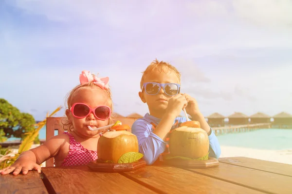Malý chlapec a batole dívka pití kokosový koktejl na pláži — Stock fotografie