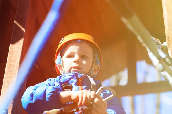 안전 장비와 모험 공원에 등반 하는 어린 소년 — 스톡 사진