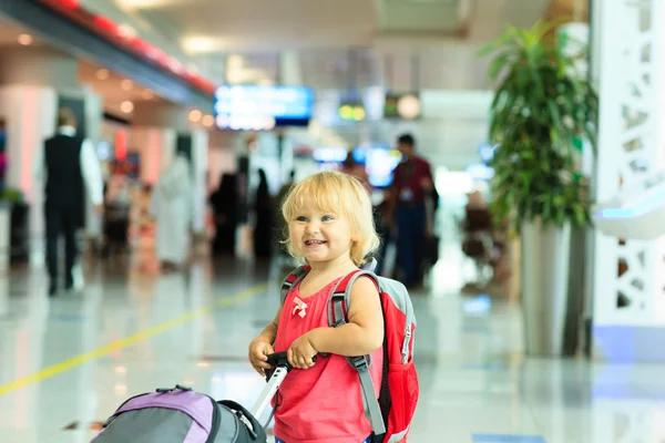 Liten flicka med resväska resor på flygplatsen — Stockfoto