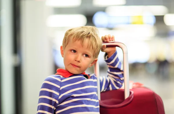 Liten pojke med resväska väntar på flygplatsen — Stockfoto