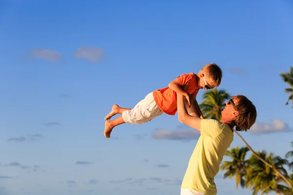 Vader en zoontje spelen op tropisch strand — Stockfoto
