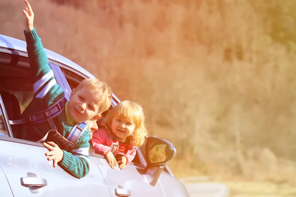 Happy little boy and girl travel by car — Stock Photo, Image