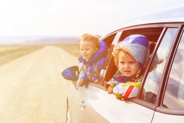 Mała dziewczynka i chłopiec podróży samochodem na drodze — Zdjęcie stockowe