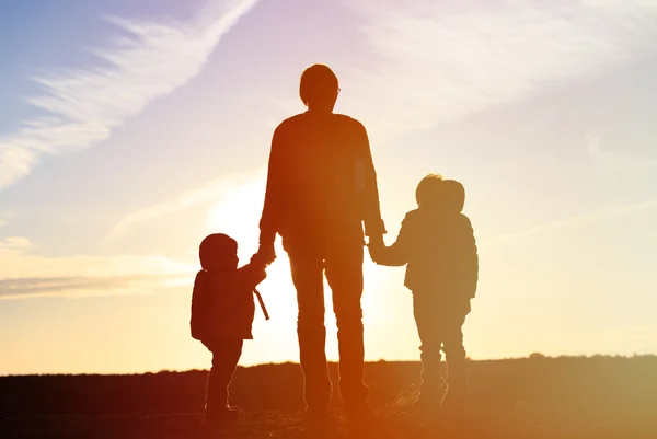 Vader en twee kinderen reizen bij zonsondergang — Stockfoto