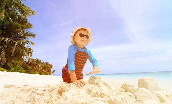 Piccolo ragazzo costruzione castello di sabbia sulla spiaggia — Foto Stock