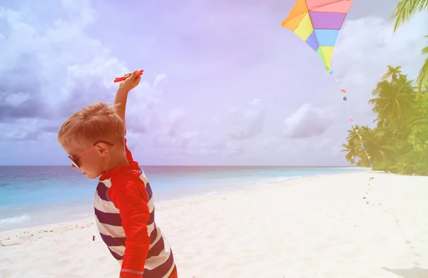 Little boy flying a kite on tropical beach — Stock Photo, Image