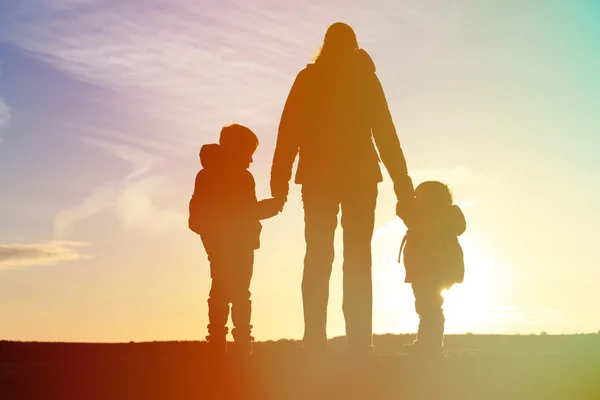 Moeder en twee kinderen reizen bij zonsondergang — Stockfoto