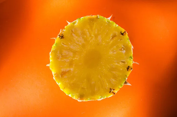 Jeden plasterek ananasa na pomarańczowym tle, poziome strzał — Zdjęcie stockowe