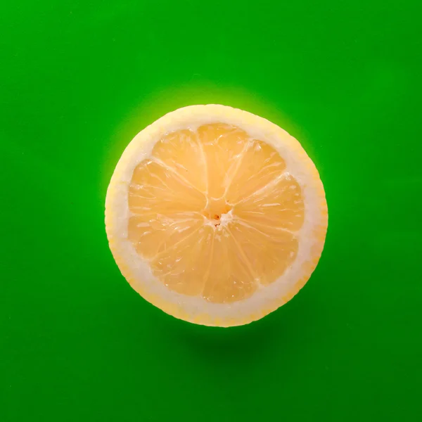 One slice of lemon on red background, square shot — Stock Photo, Image