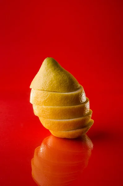 Whole sliced lemon on red background, vertical shot — Stock Photo, Image