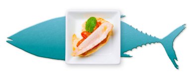 Tuna belly from the north, preserved in olive oil, in a pintxo with a slice of bread and roasted peppers on a plate on a metallic tuna silhouette isolated on white background.Panoramic image. clipart