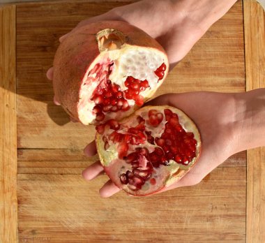 Ahşap arka planda elde açık nar. Üst görünüm