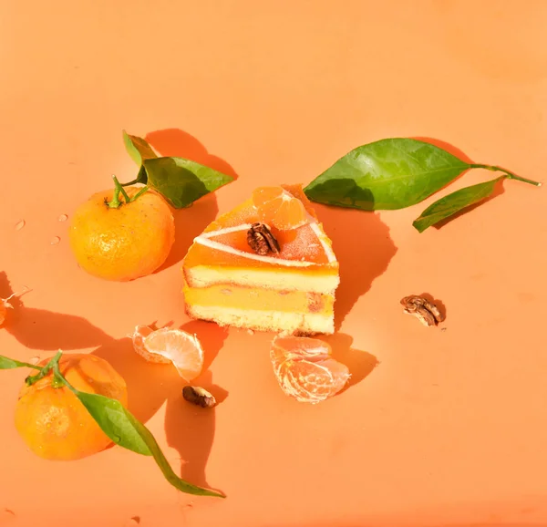 Piece Orange Cake Tangerines Leaves Orange Background — Stok fotoğraf