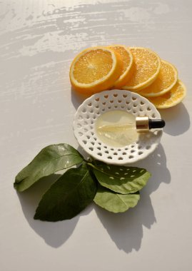 Beyaz Tabaktaki Serum Damlası Citrus Dilimleri ve Beyaz Arkaplanda Yeşil Yapraklar Arasında, Boşluğu Kopyala