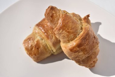 Doğal Güneş Işığında Beyaz Tabakta Taze Altın Kruvasanlar