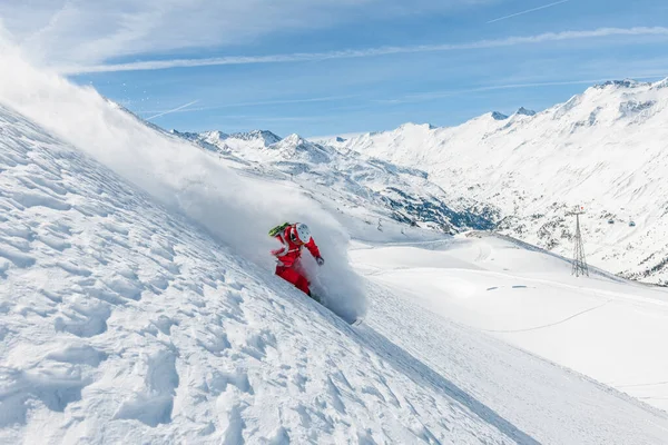 深いパウダースノーの中で速く滑るフリーライドスキーヤーのストック写真 背景には大きな山と青空 場所はオーストリアのHochgurglとObergurglです — ストック写真