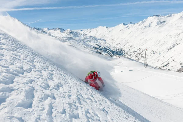 一个自由式滑雪者在厚厚的粉雪中快速滑下山坡的照片 后面是大山和蓝天 地点是奥地利的Hochgurgl和Obergurgl — 图库照片