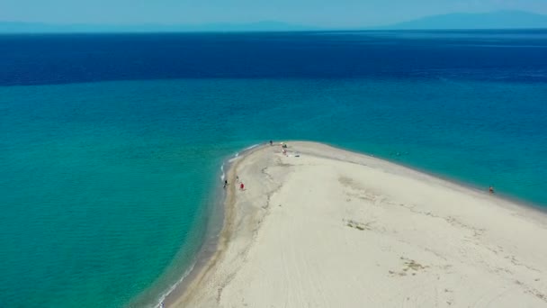 ギリシャのアクティ カッサンドラ ハルキディキ ビーチを飛行するドローン いくつかの人々が歩いている砂浜の上を飛行し その後 美しい澄んだ青い海を渡ります — ストック動画