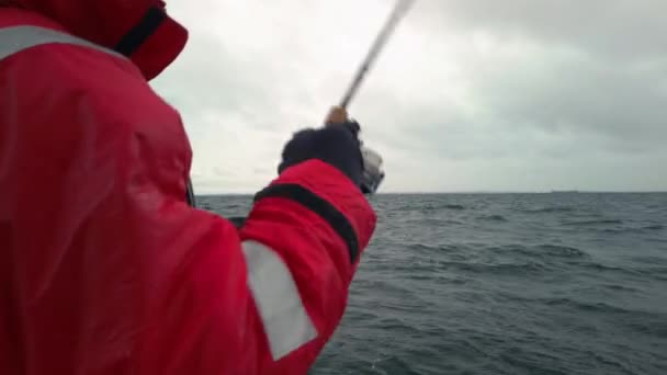 釣り人オープン海の上に小さなボートの上にタラのジグ 灰色で曇りの冬の日です 波が船を上下に揺らし — ストック動画