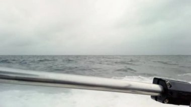 Hızlı balıkçı teknesi denizde su sıçratan dalgalar yaratıyor. Tekne okyanus üzerinde hızla yol alır ve dalgalara çarptığında su püskürtür. Danimarka, Resund 'da gri ve bulutlu bir kış günüdür. 1080p