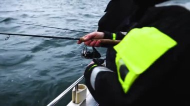 İki balıkçı açık denizde küçük bir teknede morina avlıyor. Gri, bulutlu bir kış günü. Dalgalar tekneyi yukarı aşağı sallıyor. 1080p