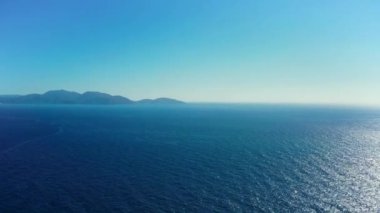 Yunanistan 'ın Alaties kentindeki güzel, berrak okyanusa bakan insansız hava aracı. Kamera daha sonra dalgaların vurduğu kayalık sahili gösteriyor. 1080p