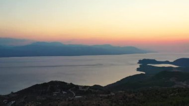 Yunanistan 'daki Gerania dağında güzel bir günbatımının insansız hava aracı görüntüleri. Drone, güneşin battığı yere, denize bakıyor, sonra da Gerania Dağı 'nın yamacını görmek için sağa dönüyor. 1080p