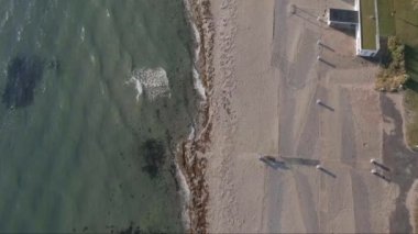 Bellevue, Klampenborg, Kopenhag, Danimarka 'nın küçük sahil görüntüleri. İHA sahilin üzerinde uçar, karenin sol tarafında deniz, ve sağ tarafında karaya çıkar. Kamera aşağı bakıyor. Güzel güneşli bir sonbahar günü.