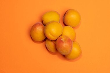 Küçük, taze, olgun, sulu şeftali yığını. Renkli bir arkaplan, stok resmi..