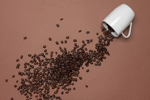 Жареные Кофейные Зерна Разбросаны Цветном Фоне Бобы Выложены Чаши Белого — стоковое фото