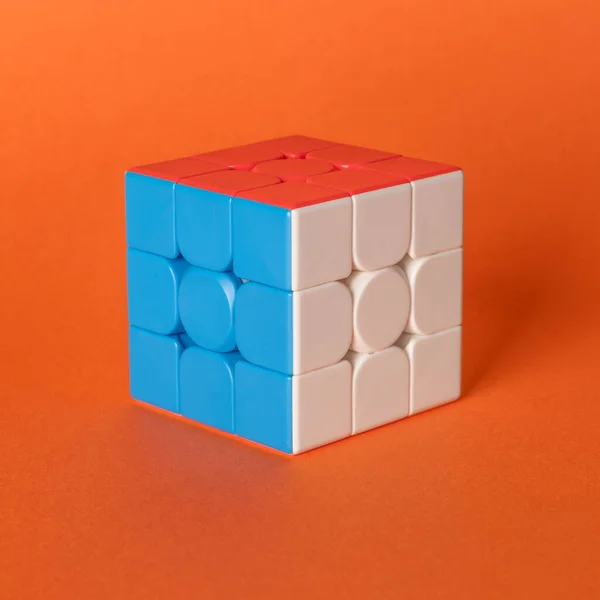 Kleurrijke Rubik Kubus Geplaatst Een Gekleurde Achtergrond Zijn Drie Kanten — Stockfoto