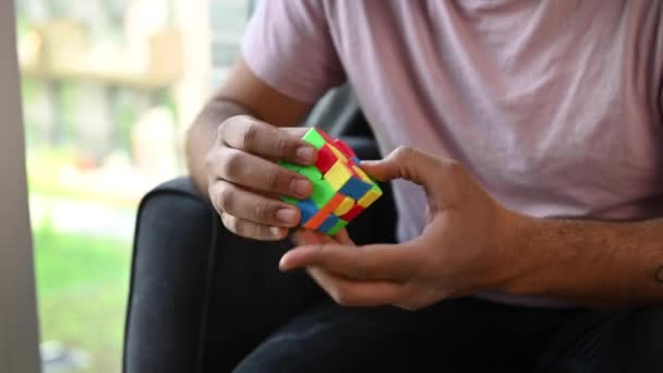 Mladý Muž Sedí Křesle Pohodlí Svého Domova Řeší Puzzle Rubikovy — Stock video