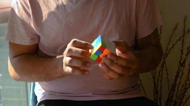 Kendi Evinde Rahat Bir Sandalyede Oturan Genç Adam Rubiks Küpünün — Stok video