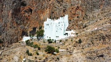 İnsansız hava aracı Yunanistan 'daki Hazoviotissa manastırına doğru uçuyor. İnsansız hava aracı, dağa oyulmuş güzel ve etkileyici manastıra doğru yavaşça ilerliyor. Hava aracı 4K stok görüntüsü