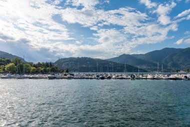 Como Gölü 'nün ve Como Kasabası' ndan görülen marinanın manzarasına bakın. Güzel güneşli bir yaz günü, mavi gökyüzü ve birkaç bulutla. Yat limanında bir sürü tekne ve sandal var.