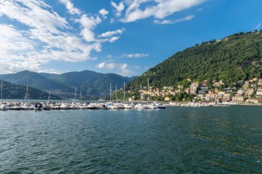 Como Gölü 'nün ve Como Kasabası' ndan görülen marinanın manzarasına bakın. Güzel güneşli bir yaz günü, mavi gökyüzü ve birkaç bulutla. Yat limanında bir sürü tekne ve sandal var.