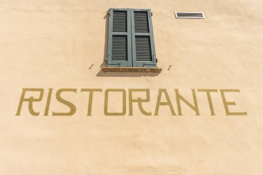 Duvarda Ristorante yazıyor. Lenno, Como Gölü, Lombardy, İtalya 'da bir binanın duvarında restoran tabelası var..