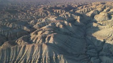 Renkli çizgili katmanlı tortulu dağların ve Kazakistan 'daki Altyn Emel ulusal parkındaki eşsiz erozyon jeolojik deseninin havadan görünüşü.