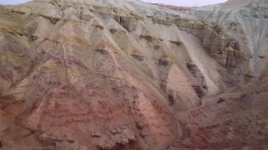 Renkli çizgili katmanlı tortulu dağların ve Kazakistan 'daki Altyn Emel ulusal parkındaki eşsiz erozyon jeolojik deseninin havadan görünüşü.