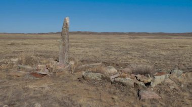 Taş heykel bozkırda duruyor. Balbal göçebesi.