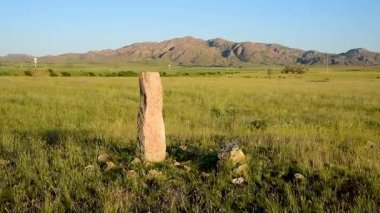 Taş heykel bozkırda duruyor. Balbal göçebesi.