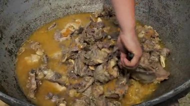 Kazanda kavrulmak. Kaynayan, et ile zengin bir çorba kızarır ve yakın plan bir kazanda pişirilir..