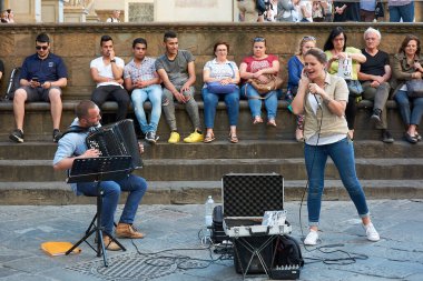 19 Mayıs 2017 - FLORENCE, ITALY: Piazza della Signoria 'nın bitişiğindeki gösteriden keyif alan bir grup insanla sokak müzisyenlerinin muhteşem bir sokak konseri vermesinin ön görüntüsü.