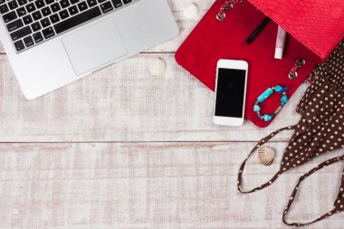 Moda kadın aksesuarları. Lüks el yapımı yılan derisi (piton) çanta, kozmetik, makyaj aksesuarları moda seti, dizüstü bilgisayar, akıllı telefon. Üst görünüm, düz yatıyordu, açık ahşap arka plan. Metin için boş/boş alan.